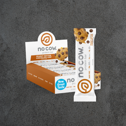 A box and single wrapped No Cow protein bar in Peanut Butter Chocolate Chip flavor, displayed on a dark textured gray background.